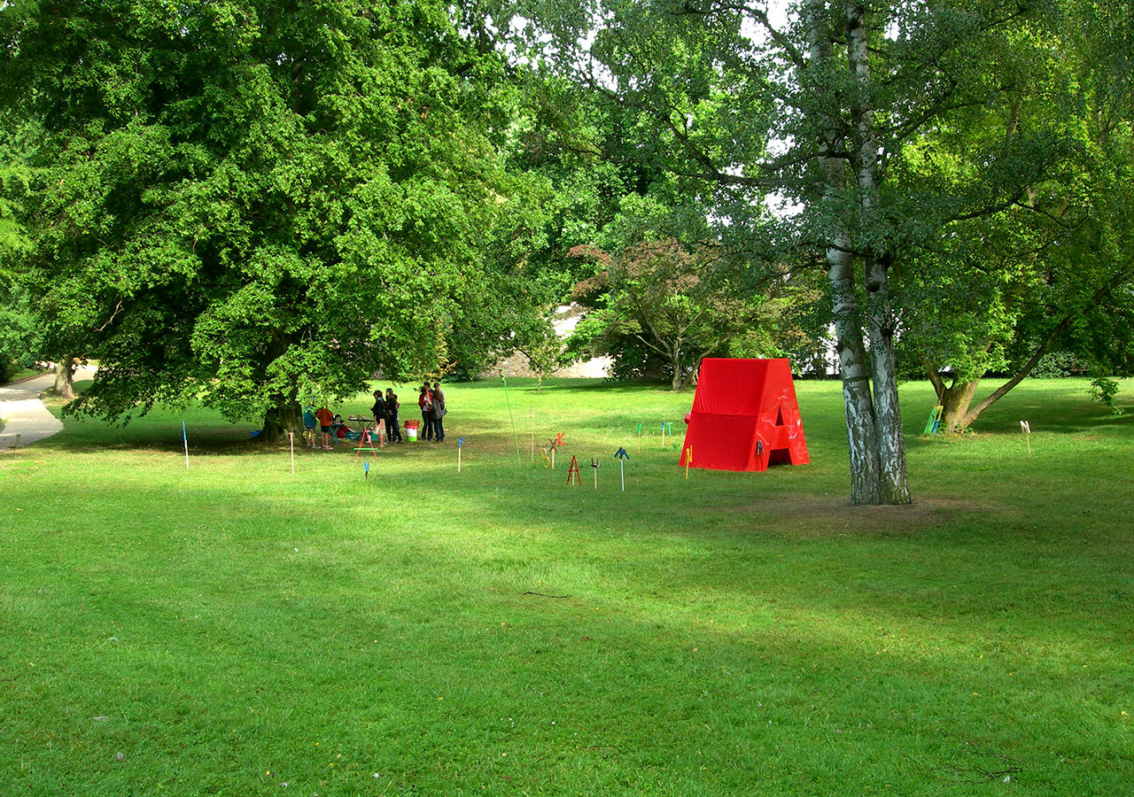 Umgeben von kleinen, verstellbaren Buchstaben, leuchtet das „Worthaus“ im Schlosspark nach dem Regenguss