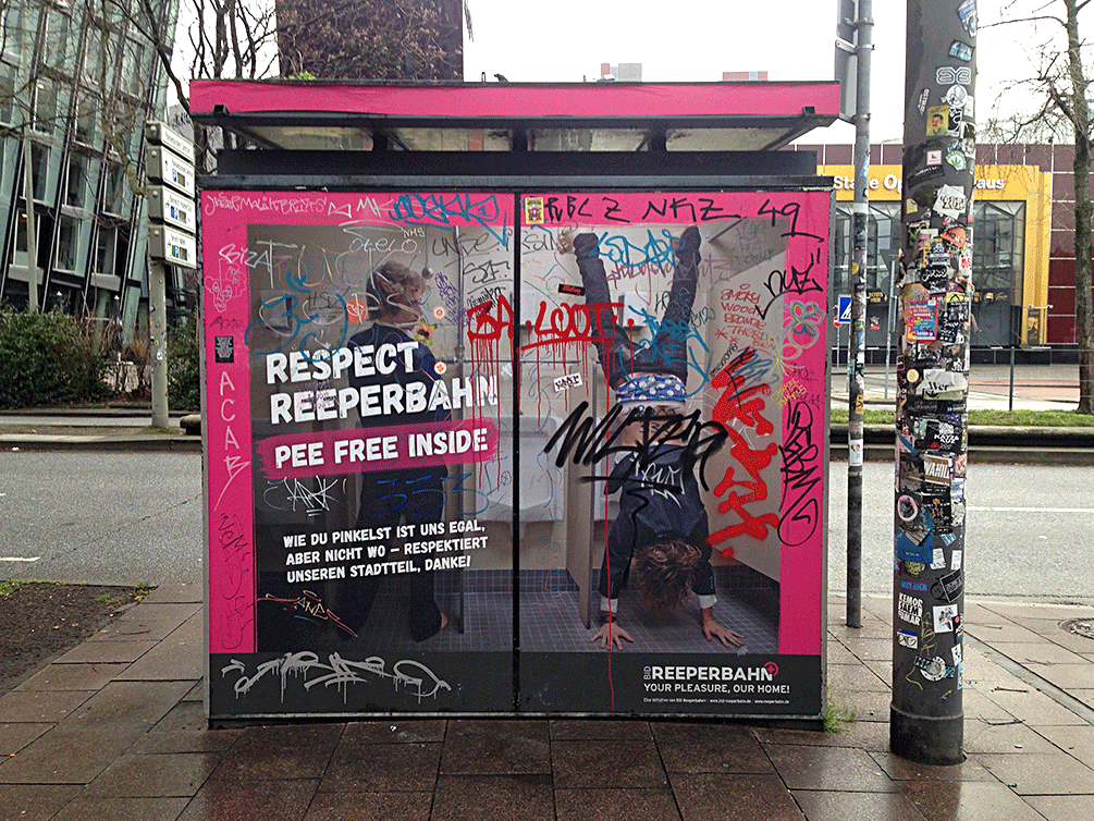 Ein öffentliches Klo auf der Reeperbahn in Hamburg. Die Fassade ist mit einem lustigen Werbebild beklebt mit dem Spruch „Pee free inside“.
